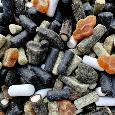 Verschiedene würzige Lakritzsorten in einem Mix – mit Süßholz, Minze, Honig und Salmiak, lose gemischt in einer Tüte.